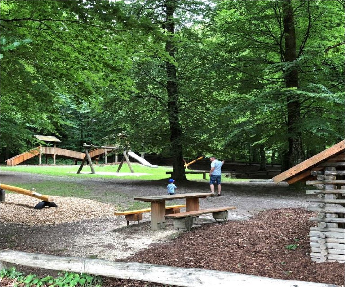 Waldspielplatz mit Sitzgelegenheiten und Spielhäuschen